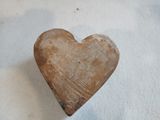 un petit objet en forme de cœur posé sur une surface blanche