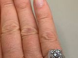 a woman ' s hand with a diamond ring on it