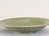 a green bowl sitting on a table with a white background