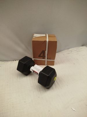 une paire d'haltères posée sur un lit, avec une boîte en arrière-plan