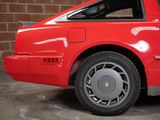 a red car parked in front of a brick wall