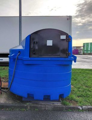 un réservoir bleu muni d'un tuyau, situé à côté d'une borne d'incendie