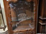 un meuble en bois avec une porte en verre dans une pièce