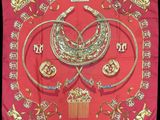 an image of a red scarf with gold jewelry on it
