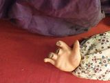 a doll that is laying on a bed with a purple blanket