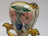 a vase that is sitting on a plate with a flower design on it