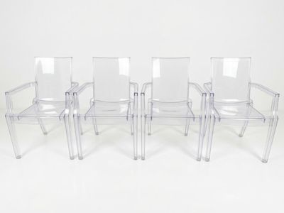 trois chaises en plastique transparent placées les unes à côté des autres sur une surface blanche