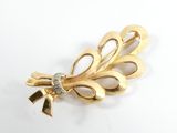 an image of a gold brooch with a diamond in the center