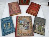 several books are lined up on a table with a white table cloth