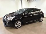 a black car is parked in a large room