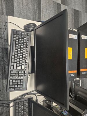plusieurs écrans d'ordinateur et un clavier posés sur le bureau