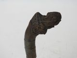 a close up of an old walking stick with a carved handle
