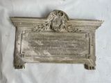 une plaque fixée au mur d'un bâtiment sur lequel est apposée une plaque
