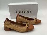 a pair of brown and tan shoes with a box in the background