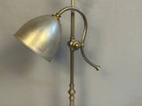 une lampe de table ancienne en laiton avec un abat-jour en métal, sur fond blanc