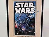 a framed star wars movie poster on display in a black frame