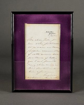 an old letter is displayed in a purple frame on a gray surface