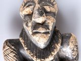 an old statue of a man with his eyes closed sitting on a white surface