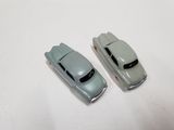 two toy cars that are sitting on a white surface