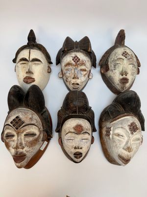 plusieurs masques africains accrochés au mur d'une pièce