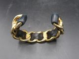 un gros plan d'un bracelet doré et noir posé sur une table