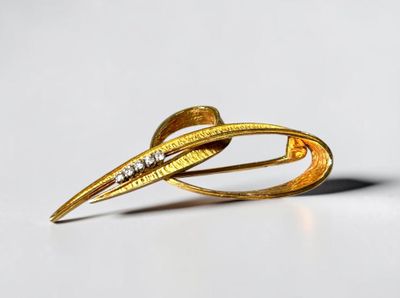a close up of a gold brooch with diamonds on it
