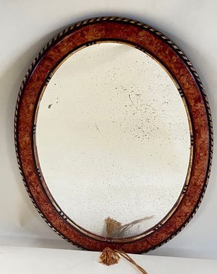a mirror hanging on the wall with a rope around it