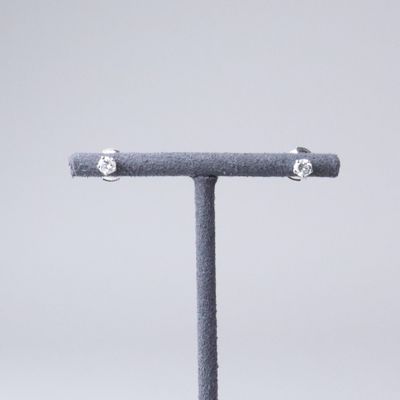 an image of a pair of diamond stud earrings sitting on top of a stand