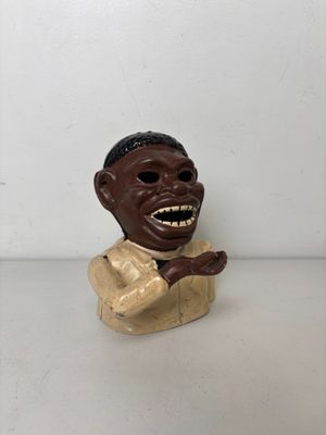 une petite statue représentant un homme avec un grand sourire