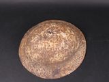 a rusted metal object on a black surface