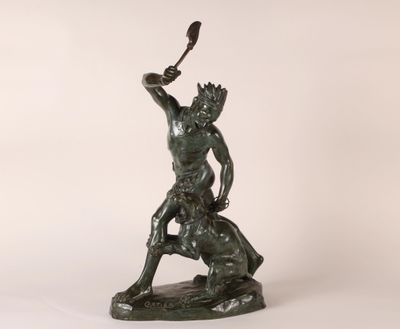 a bronze statue of a man holding a knife in his hand