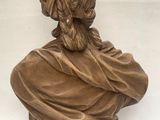 bronze bust of a woman wearing a hat and a dress