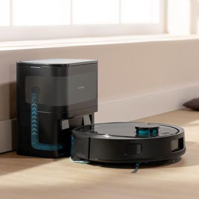 an image of a robotic vacuum cleaner sitting on the floor next to a box