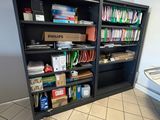 a black bookcase with many items on it in a room