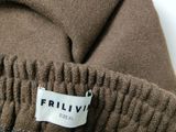 the label is on the back of a brown sweater