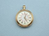 a small gold pocket watch on a blue surface