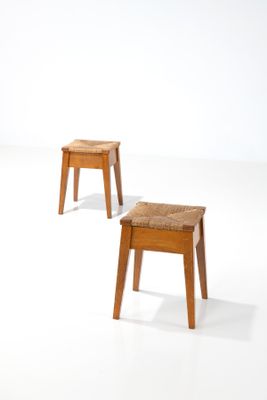 deux petits tabourets placés l'un à côté de l'autre sur une surface blanche