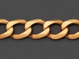gros plan d'un bracelet en or sur une surface grise