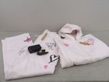 a pair of white pants and a cell phone on a bed