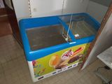 a blue and white ice cream freezer in the corner of a room
