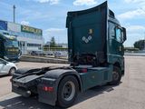 a green truck that is parked in a parking lot