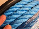 a person holding a blue rope wrapped in plastic