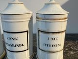 three white canisters with black labels on them sitting on a table