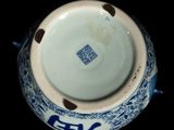 a close up of a blue and white vase on a black background