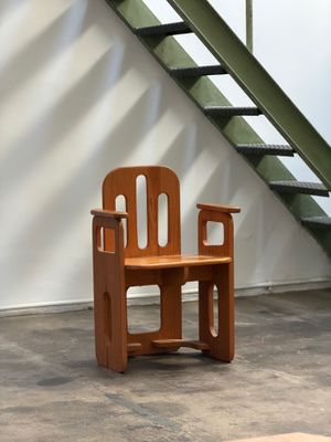 une chaise en bois posée devant un escalier