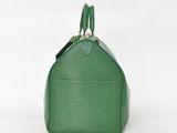 a green louis vuitton bag on a white background