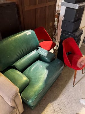 a man standing next to a couch and chair in a living room