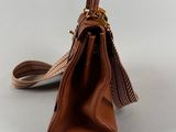 the small brown bag is sitting on a white surface