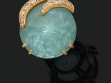 Gros plan d'une bague posée sur une surface noire, sur fond noir