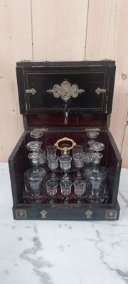 des bouteilles et des verres dans une caisse en bois posée sur une table en marbre